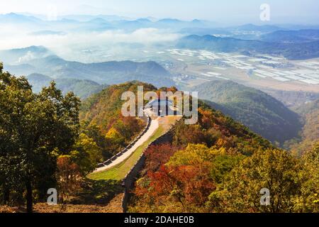 Wunderschöne koreanische Herbstlandschaft. Bunte Herbstblätter von der Spitze des Berges und traditionelle Gebäude entlang der Burgstraße gesehen. Stockfoto