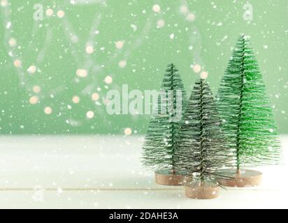 Miniatur Spielzeug Weihnachtsbäume auf einem Holztisch mit Schnee. Imitierte realistische Szene. Banner. Stockfoto