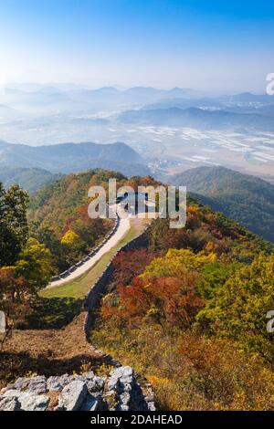 Wunderschöne koreanische Herbstlandschaft. Bunte Herbstblätter von der Spitze des Berges und traditionelle Gebäude entlang der Burgstraße gesehen. Stockfoto