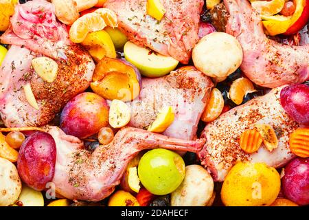 Stücke von rohem Kaninchenfleisch mariniert mit Früchten Stockfoto
