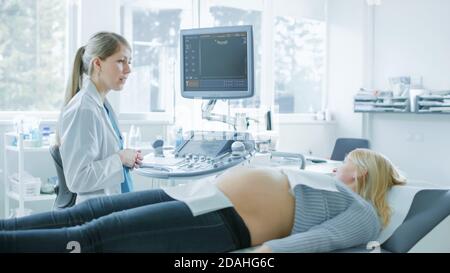 Im Krankenhaus, schwangere Frau bekommen Ultraschall-Sonogramm-Scan, Geburtshelfer erklärt Verfahren. Glückliche Frau wartet auf ihr erstes Baby. Stockfoto