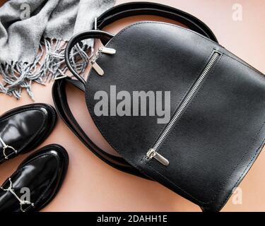 Damen Rucksack aus schwarzem Leder, Schuhe und Schal. Damen Leder Mode Accessoires. Flach liegend, Draufsicht. Herbstmodekonzept in schwarz Stockfoto