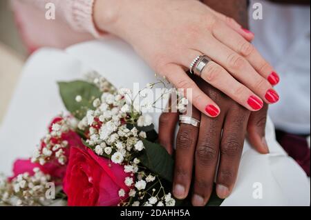 Glückliches multiethnisches Paar in Liebesgeschichte. Beziehungen von afrikanischem Mann und weißer europäerin. Hände mit Ringen. Stockfoto