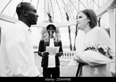Hochzeit Verlobungszeremonie mit Pastor. Glückliches multiethnisches Paar in Liebesgeschichte. Beziehungen von afrikanischem Mann und weißer europäerin. Stockfoto