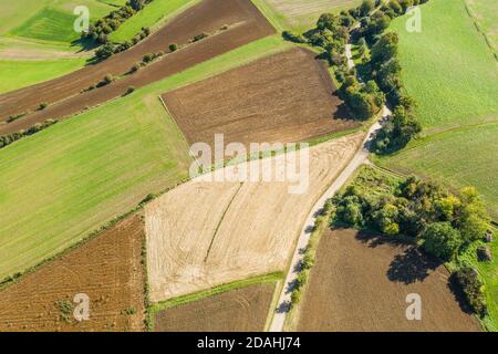 Bild von einer Luftaufnahme von Wiesen und Feldern einer ländlichen Gegend mit Feldweg und Bäumen und Ackerland in Bayern, Deutschland Stockfoto