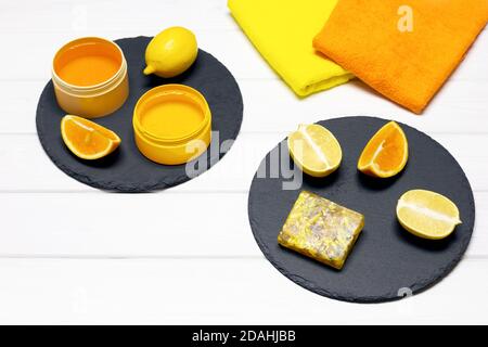 Natürliche Bio-Hautpflege Kosmetik-Konzept. Hausgemachte Zitrusseife mit Zitronen, Orangen und Handtüchern auf weißem Holztisch. Speicherplatz kopieren Stockfoto