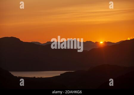 Ein wunderschöner goldener Sonnenuntergang hinter dem Skye Ridge, von nahe Arnisdale, Schottland Stockfoto