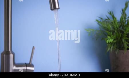 Klares und frisches Wasser fließt durch den Haushahn, frisches und reines Hauswasser, Trinkwasser ist ein gesunder Lebensstil. Ökologische und gesunde Getränke Stockfoto