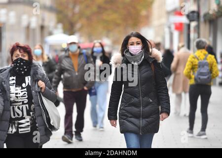 München, Deutschland. November 2020. Maskenpflicht in den Fußgängerzonen und öffentlichen Plätzen in München am 11.11.2020. Junge Frau mit Alltagsmaskentelefon mit Smartphone, Menschen gehen mit Gesichtsmasken, Maske durch die Innenstadt, Kaufinger Straße, Neuhauser Straße, MODEL RELEASED! Quelle: dpa/Alamy Live News Stockfoto