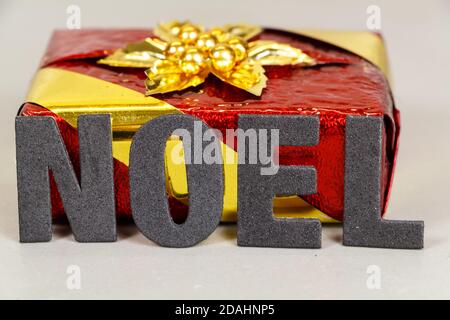 Rot und goldenes Geschenk und das Wort Weihnachten geschrieben in französisch Stockfoto