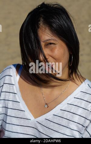 Vertikales Porträt einer lächelnden schönen hispanischen Frau Stockfoto