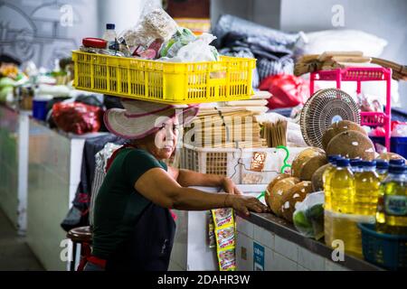 Denpasar, Bali, Indonesien - 8. AUGUST 2019 : neugieriges Porträt einer Frau, die einen Korb auf dem Kopf bringt. Stockfoto