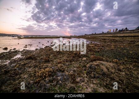 Malerischer Blick auf einen Korallenstrand bei einem magischen Sonnenuntergang mit Wolken, Nusa Penida, Bali Indonesien Stockfoto