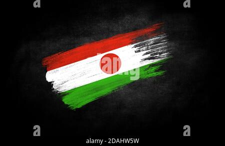 Schmieren der Farbe in Form der Flagge von Niger Nahaufnahme auf schwarzem Hintergrund Stockfoto