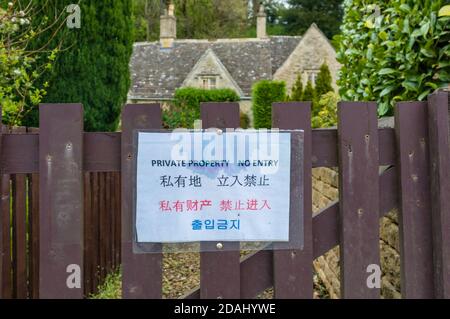 Privateigentum, kein Eintrittschild in japanischen, chinesischen und koreanischen Schriftzeichen am Vordertor einer Hütte im Dorf Bibury, Cotswolds Stockfoto