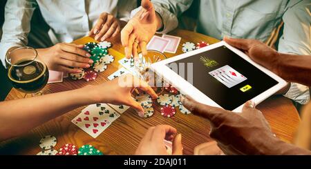 Online-Glücksspiel, Casino-Konzept. Handhaltevorrichtung mit Lotterie, Casino Abdeckung. Spielen Dips und Karten auf dem Tisch auf dem Hintergrund. Poker, Buchmacher, Gaming, moderne Technologien, Business und Finanzen. Stockfoto