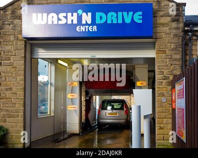 Auto wird in einer automatischen Waschanlage mit großen Bürsten gereinigt. Stockfoto