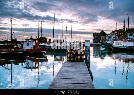 Urk Flevoland Holland, ein Paar Männer und Frauen, die den Sonnenuntergang beobachten Kleiner Fischerdorf Hafen von Urk Niederlande Stockfoto