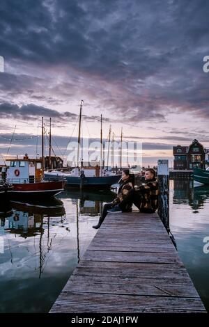 Urk Flevoland Holland, ein Paar Männer und Frauen, die den Sonnenuntergang beobachten Kleiner Fischerdorf Hafen von Urk Niederlande Stockfoto