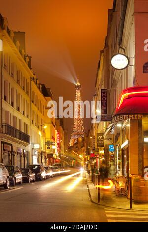 Paris, Frankreich - Nachtleben in Pariser Cafés mit dem Eiffelturm im Hintergrund. Stockfoto