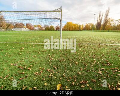Coronavirus Covid 19 Pandemie. Blick durch Torwart Tor zu verlassenen Fußballstadion. Fußball Spielplatz Rasen Feld. Stockfoto
