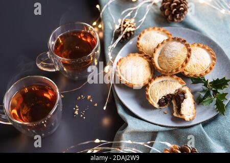 Die Torten auf einem Teller von oben geschossen zerkleinern. Ein Mince Pie ist ein traditioneller Weihnachtskuchen, gefüllt mit einer Mischung aus getrockneten Früchten und Gewürzen. Stockfoto