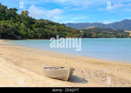 Kleines Schlauchboot aus Metall an einem Sandstrand. Wyuna Bay, Coromandel Peninsula, Neuseeland Stockfoto