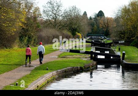 Menschen, die im Herbst bei Lapworth Locks auf dem Stratford-upon-Avon Canal, Warwickshire, Großbritannien, spazieren gehen Stockfoto