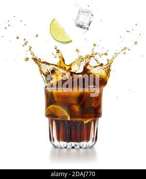 Limettenkeil und Eiswürfel, die in eine spritzende Cola fallen Trinken Stockfoto