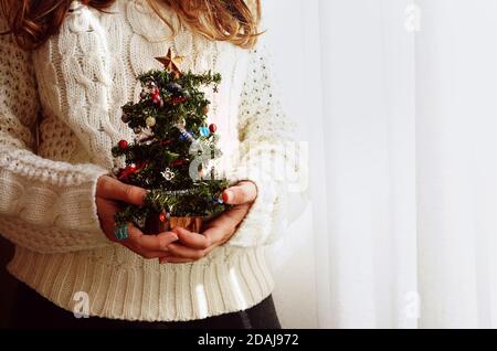 Frau, die einen Weihnachtsbaum hält. Stockfoto