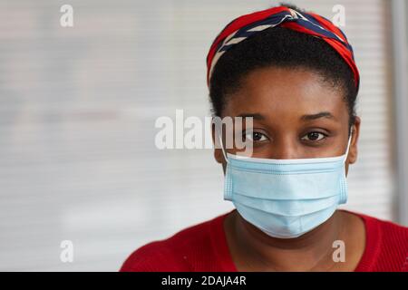 Nahaufnahme einer afrikanischen Frau mit Schutzmaske und Blick auf die Kamera Sie schützt sich vor Krankheiten Stockfoto