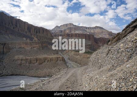 Eine unbefestigte Straße führt nach Upper Mustang am Ufer des Kali Gandaki Flusses entlang, inmitten der Himalaya Berge in Nepal. Stockfoto