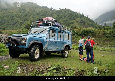 Local Resident zeigt dem Touristen die Richtung der Straße, steht in der Nähe eines Touristen Jeep in der Nähe von Jomsom in Nepal, Mustang Bezirk. Stockfoto