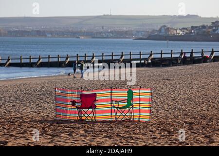 Portobello, Edinburgh, Schottland, Großbritannien. 13. November 2020. Sonne und Temperatur von 8 Grad an Land am Porty Beach Seaside. Im Bild: Eine Windschutze und Stühle am Sandstrand, bereit für ein bisschen Sonnenbaden vielleicht, oder ein Bad im Firth of Forth? Quelle: Arch White/Alamy Live News. Stockfoto