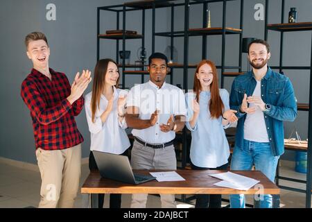 Portrait einer Gruppe von multiethnischen Geschäftsleuten, die applaudieren und dankbar sind Blick in die Kamera Stockfoto