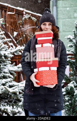 Frau auf dem Heimweg vom Einkaufen holding Haufen Weihnachtsgeschenk Boxen Stockfoto