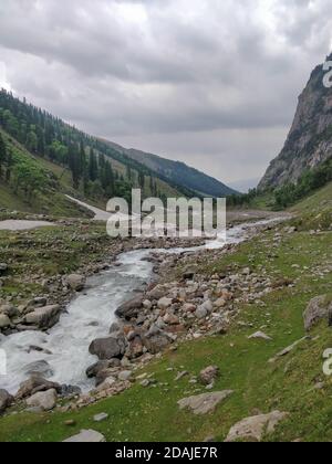 Wunderschöner Flussstrom, der durch Felsen in einem epischen indischen Himalaya Mountain Valley fließt. Stockfoto