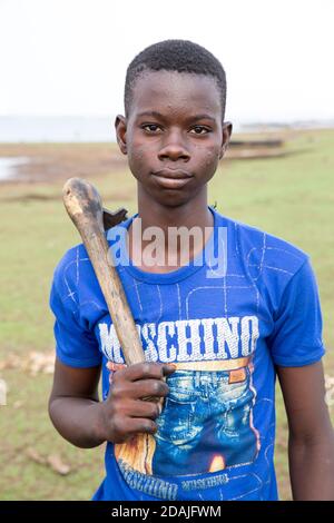 Selingue Area, Mali, 27. April 2015; Bootsbauer und Reparaturwerkstatt, Ke Karonta, 17 (blaues Hemd) war noch nie zur Schule gegangen. Sein Vater ist Bootsbauer und tritt in die Fußstapfen seines Vaters. Stockfoto