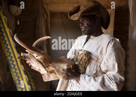 Delaba Koro, Dorf 60 km von Selingue, Mali, 27. April 2015; in diesem Dorf wurden viele Menschen vom Staudamm vertrieben. Oualama Doumbia, 56, ist Landwirt, Fischer, Jäger, Und Sohn des früheren Chefs, der in Jägerkleidung den Schädel eines Wildschweins trug, das er während der Jagd tötete. Stockfoto