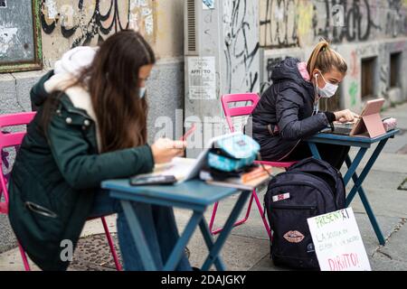 TURIN, ITALIEN - 13. November 2020: Zwei Schüler der Realschule Calvino, Anita und Lisa genannt, folgen einem Fernunterricht (Dad) auf der Straße vor ihrer Schule, um gegen die Schließung von Schulen durch die Regierung aufgrund einer Zunahme der COVID-19 Coronavirus-Infektionen verhängt zu protestieren. Anita protestiert jeden Schultag seit dem 6. November, als Piemont zu einer roten Zone wurde, einen Tag später kam Lisa zu ihr. Am 11. November erhielt Anita einen Solidaritätsaufruf von der italienischen Bildungsministerin Lucia Azzolina. (Foto von Nicol Stockfoto