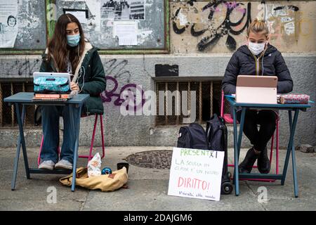 TURIN, ITALIEN - 13. November 2020: Zwei Schüler der Realschule Calvino, genannt Anita (R) und Lisa, folgen einem Fernunterricht (Dad) auf der Straße vor ihrer Schule, um gegen die Schließung von Schulen durch die Regierung aufgrund einer Zunahme der COVID-19 Coronavirus-Infektionen verhängt zu protestieren. Anita protestiert jeden Schultag seit dem 6. November, als Piemont zu einer roten Zone wurde, einen Tag später kam Lisa zu ihr. Am 11. November erhielt Anita einen Solidaritätsaufruf von der italienischen Bildungsministerin Lucia Azzolina. (Foto von Nicol Stockfoto