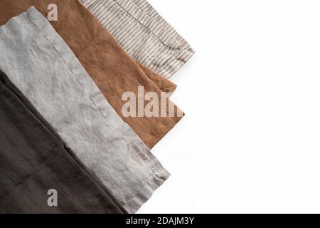 Set aus vier braunen und grauen Servietten aus reiner Leinen-Baumwolle auf weißem Hintergrund isoliert. Küchentextil Konzept, weich oder rauh Material. Leere SPA kopieren Stockfoto