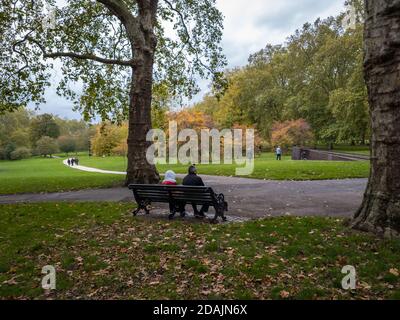 Ein Paar sitzt auf einer Bank in Green Park. London. Stockfoto