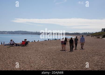 Menschen, die am Strand von Overcombe in Dorset in Großbritannien spazieren, aufgenommen am 3. August 2020 Stockfoto