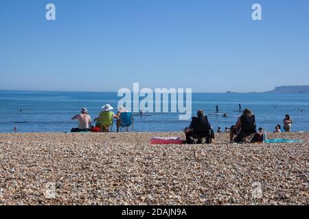 Sonnenanbeter am Overcombe Beach in Dorset in Großbritannien, aufgenommen am 3. August 2020 Stockfoto