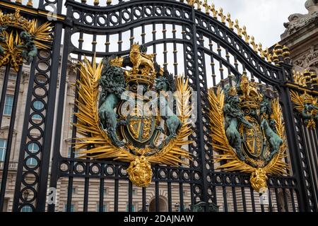 Die königlichen Wappen am kunstvollen Eisentor des Buckingham Palace. London. Stockfoto