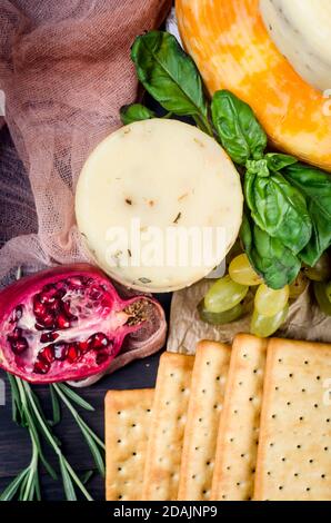 Ein Haufen Käseköpfe, Gemüse, Obst, Kekse und Nüsse auf dem Tisch Stockfoto