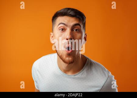 Erstaunt und verwirrt bärtiger junger Mann sieht erstaunt aus. Stockfoto