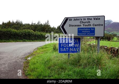 (FOLGEN SIE NICHT SAT NAV) auf Metal Road Schild in der Nähe B5322 für St. John's in der Vale Church & Youth Centre im Lake District National Park, Cumbria. Stockfoto