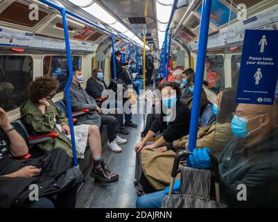 Passagiere in der Londoner U-Bahn tragen Gesichtsmaske und soziale Distanzierung. Stockfoto